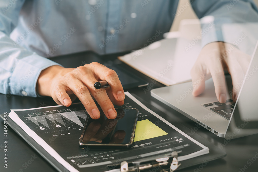 Poster close up of businessman working with smart phone and digital tablet and laptop computer on wooden de