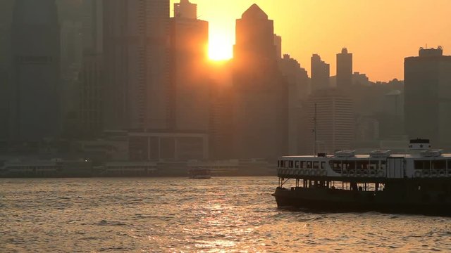 Star ferry crossing the Victoria harbour during sunset - Hong Kong