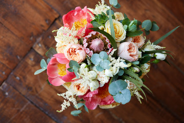 bridal bouquet with peonies and protea and boutonniere on the wooden floor