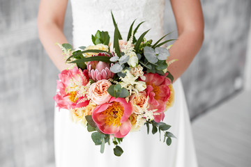 pink peony bouquet in hands of the bride
