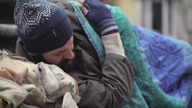 Merciful person leaves money to a homeless man sleeping in the street