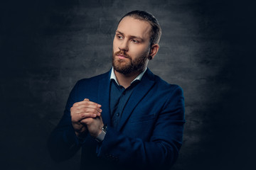 A stylish bearded male dressed in a suit and sunglasses over dark grey background.