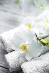 Naklejka na ściany i meble White Orchid on wooden background with towel