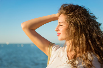 Young beautiful lady with long curly hair and closed eyes