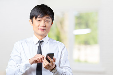 Obraz premium Asian businessman talking on mobile cell phone