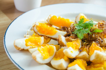 Sweet and sour eggs on the white dish.