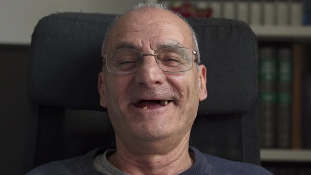 Toothless smile of an happy old man,close up
