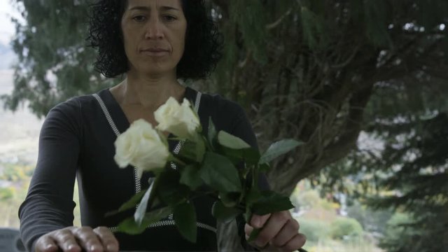 Woman visits gravestone at cemetary