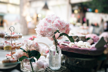 Dessert table for a party. Ombre cake, cupcakes, sweetness and flowers. selective focus