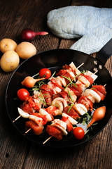 Vegetable and meat on wooden skewers on plate