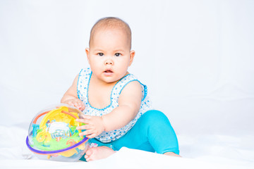 little thai baby playing toy on white background