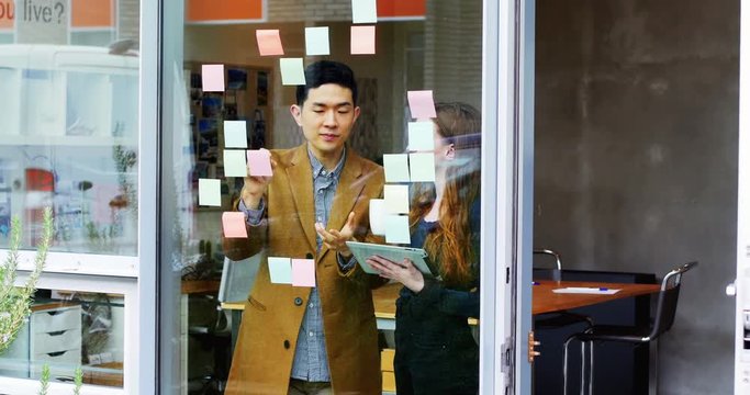 Business executives discussing over sticky notes