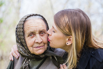 Young woman kissing her sick grandmother