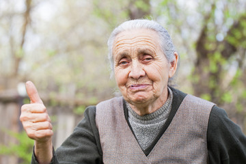 Happy senior woman showing thumb up outdoor