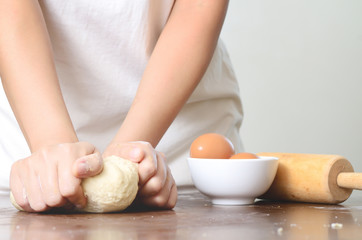 Fototapeta na wymiar Bread cooking,kneading bread dough on wooden board by hand