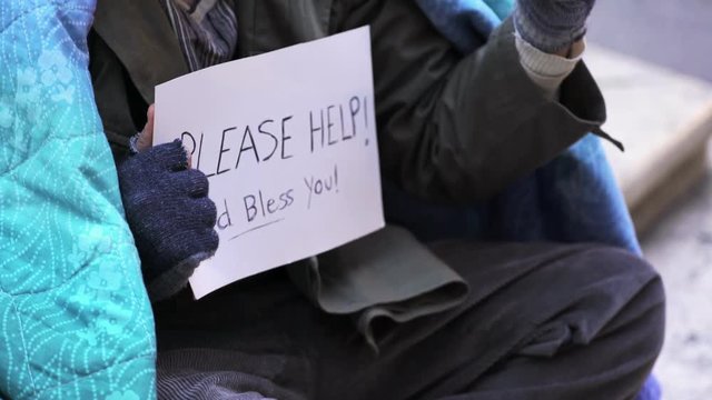 sad homeless alone asking charity in the street