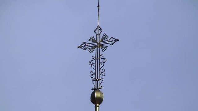 Metallkreuz der Wallfahrtskirche Maria Fieberbr&uuml;ndl vor blauem Himmel