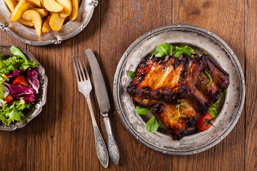 Roasted ribs, served on an old plate.