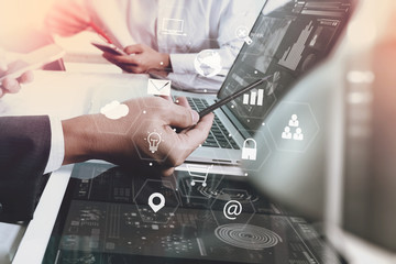 businessman working with smart phone and laptop computer on wooden desk in modern office with virtual icons interface