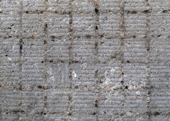Grungy gray concrete wall with square pattern.