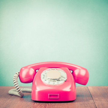 Retro old telephone on table front mint green background. Vintage style filtered photo
