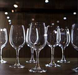 a lot of vine glasses in the dark shelf with back light