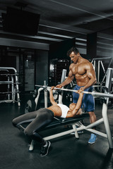 Fototapeta na wymiar Fitness instructor exercising with his client at the gym.