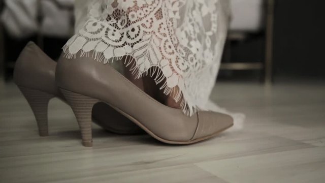 first wedding night. bride comes to a bed, removes shoes and lace dress