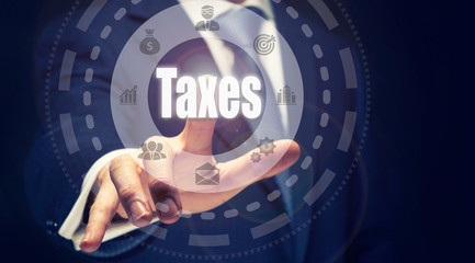 A finger pushing a Taxes Concept