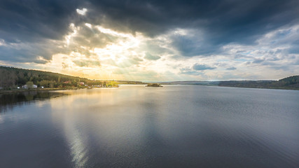 Fototapeta na wymiar Sun and clouds over a lake