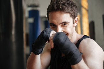 Plakat Close up view of smiling boxer doing exercise in gym