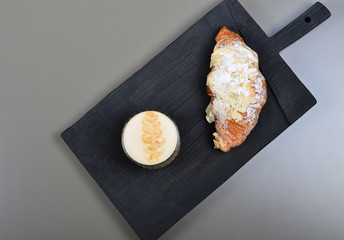 A cup of cappuccino coffee on a gray background