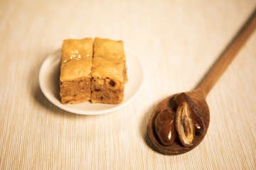 pâtisseries orientales et cuillère de bois avec des dattes 