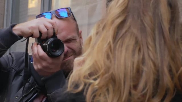 Photographer takes photos of blonde  model in the street