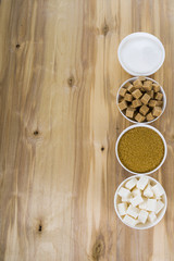 Different kind of white and brown sugar on old brown table