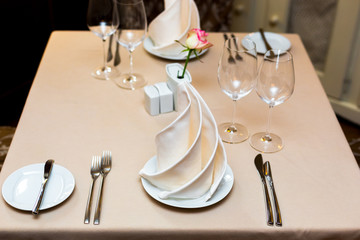 Pink rose in a vase as table decoration. Table setting