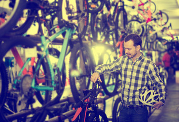 Fototapeta na wymiar Man considers bicycle handlebar in store