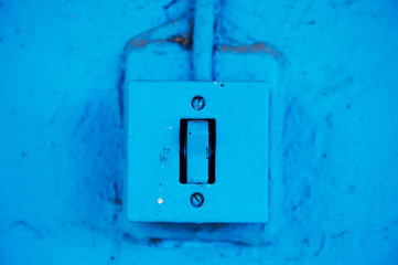 The old switch in the web on the blue brick wall. Vintage