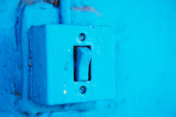 The old switch in the web on the blue brick wall. Vintage
