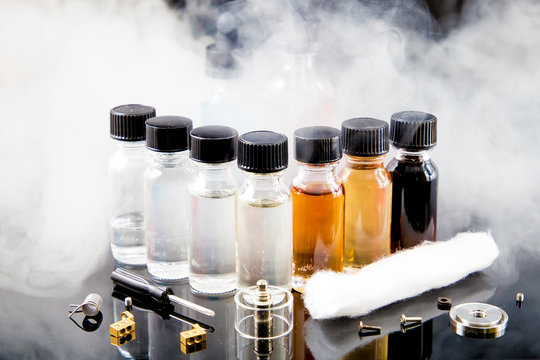 Electronic cigarette liquids with smoke on background