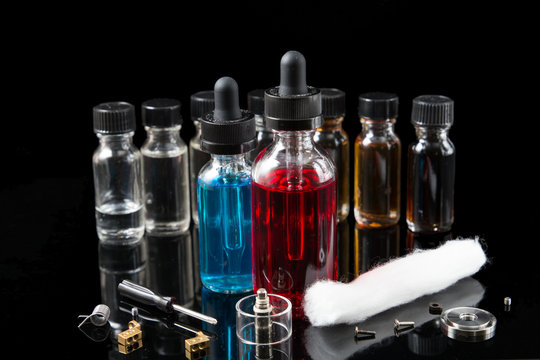 Electronic cigarette liquids and equipment on black background