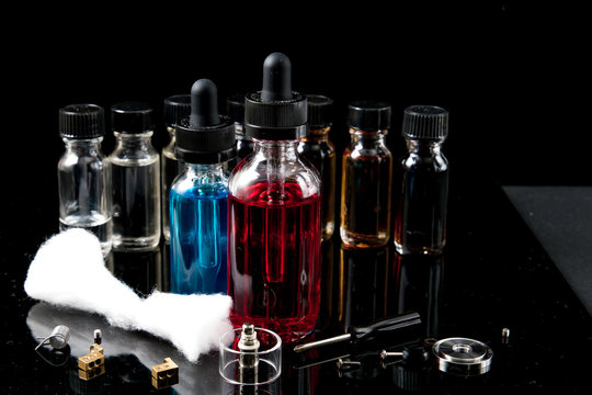 Electronic cigarette liquids with equipment on black background