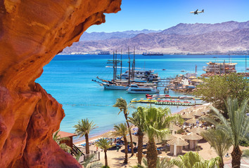 Image with central public beach of Eilat - famous resort city in Israel. Image symbolizes vacation, resting and recreation 

