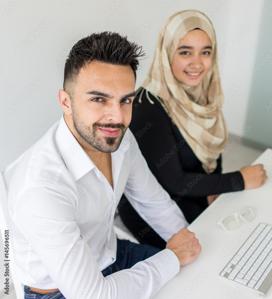 Wall mural Young mand and woman working in office on computer