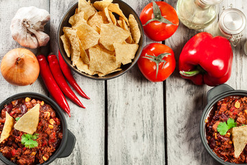Bowls of hot chili con carne with ground beef, beans, tomatoes a