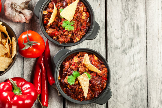 Bowls of hot chili con carne with ground beef, beans, tomatoes a