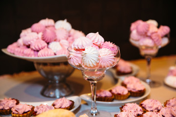 Obraz na płótnie Canvas Wedding cake. Candy bar marshmallow on the table in a vase, macaroon, and cupcake, decor vanilla, handmade sweets