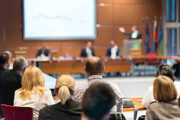 Speaker giving a talk on corporate business event. Audience at the conference hall. Business and...