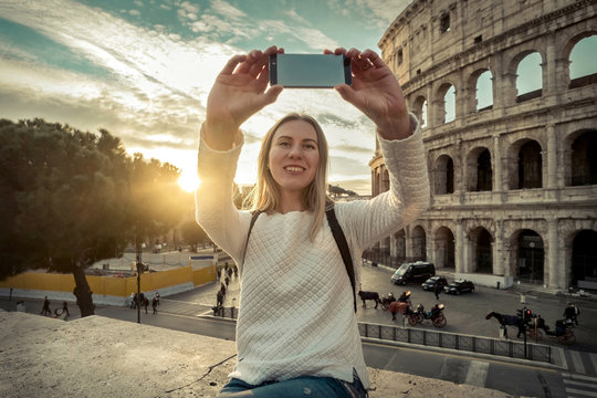 Woman tourist selfie with phone camera in hands near the Coliseu