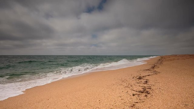 Crimea, sea surf on the beach coast of the Black Sea in cloudy weather.